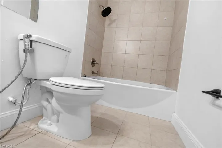 Full bath featuring shower / washtub combination and light tile patterned floors