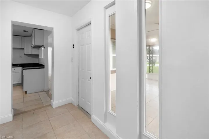 Corridor with light tile patterned floors and baseboards