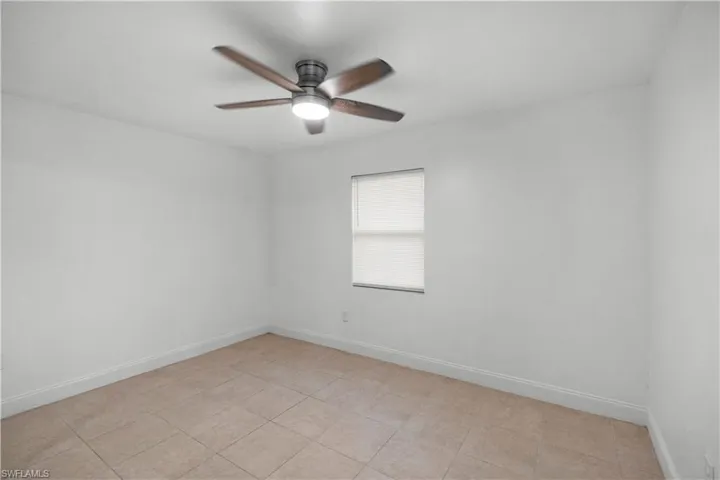 Unfurnished room with ceiling fan and light tile patterned floors