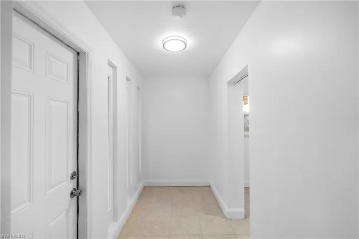 Corridor with baseboards and light tile patterned floors