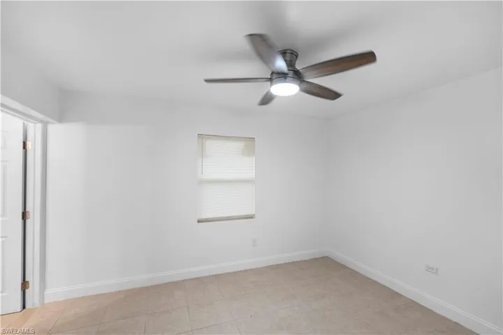 Empty room with baseboards and a ceiling fan