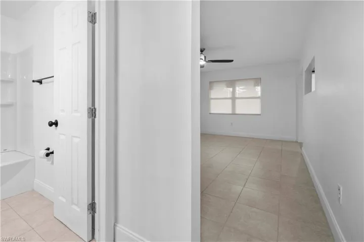 Corridor featuring light tile patterned floors and baseboards