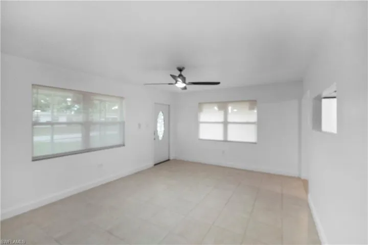 Empty room featuring light tile patterned floors and a ceiling fan