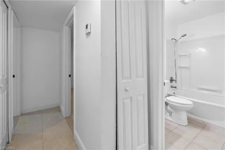 Bathroom with a closet, light tile patterned floors, and bathtub / shower combination