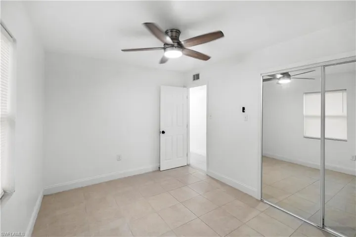 Unfurnished bedroom featuring a closet, ceiling fan, and light tile patterned floors