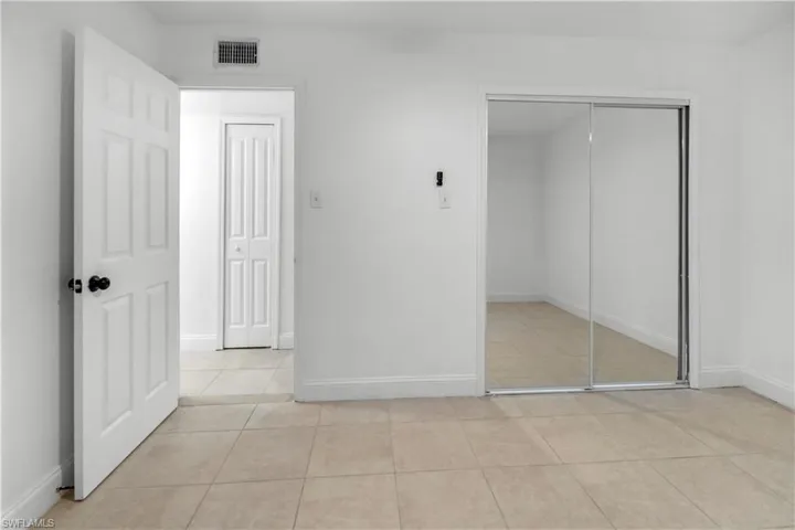 Unfurnished bedroom with a closet and light tile patterned floors