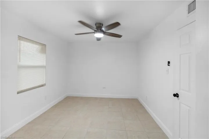 Empty room with ceiling fan and baseboards