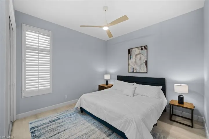 Bedroom with ceiling fan, multiple windows, and light hardwood / wood-style floors