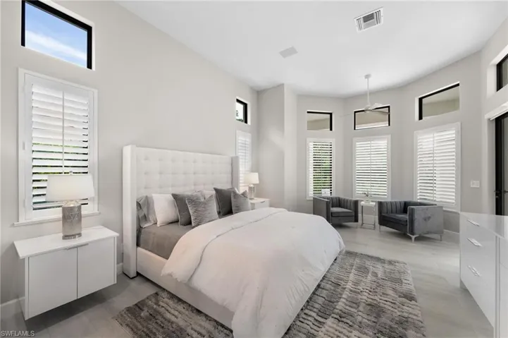 Bedroom featuring a towering ceiling and hardwood / wood-style floors