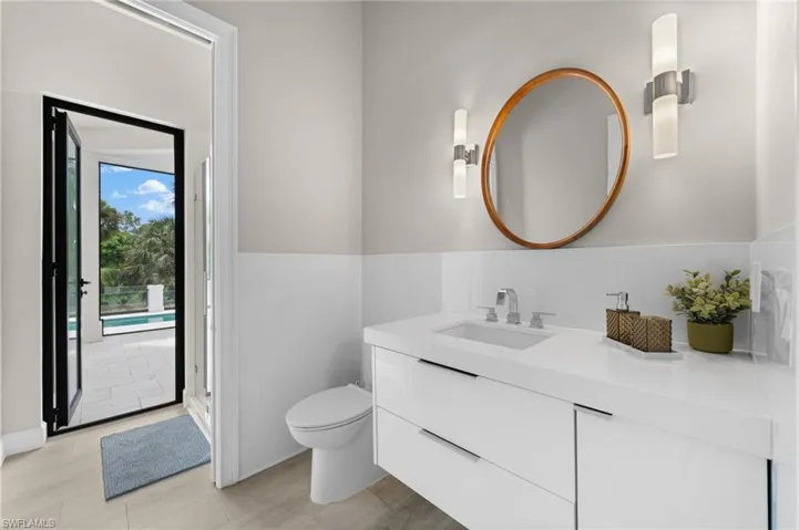 Bathroom featuring vanity with extensive cabinet space, an enclosed shower, and toilet
