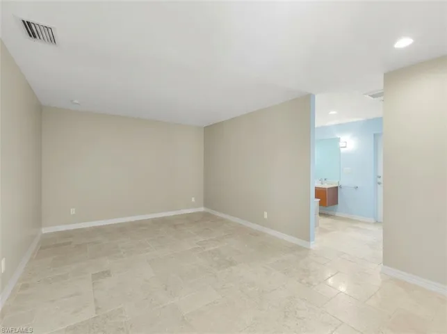 Expansive room featuring light-colored tile flooring, neutral wall paint, and recessed ceiling lighting