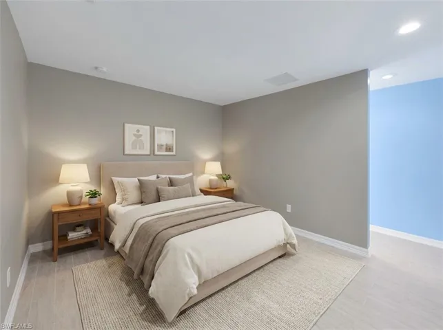 Spacious room featuring light wood-finish flooring, recessed lighting, and a neutral wall color