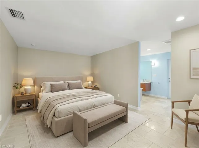 Spacious bedroom featuring light-toned walls, recessed lighting, and tile flooring