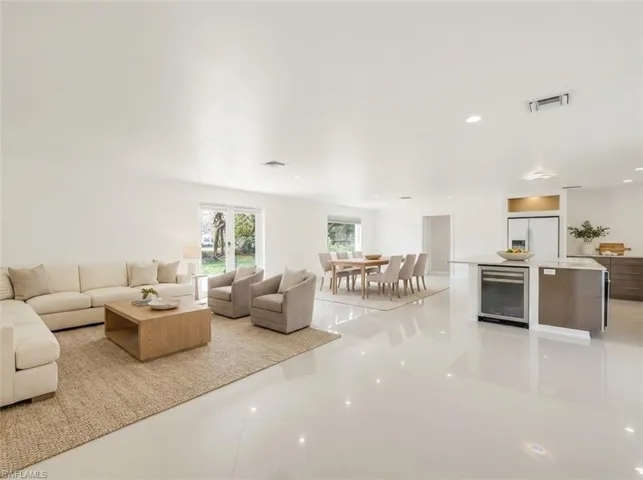 Spacious open-concept interior featuring polished tile flooring, recessed lighting, and white walls