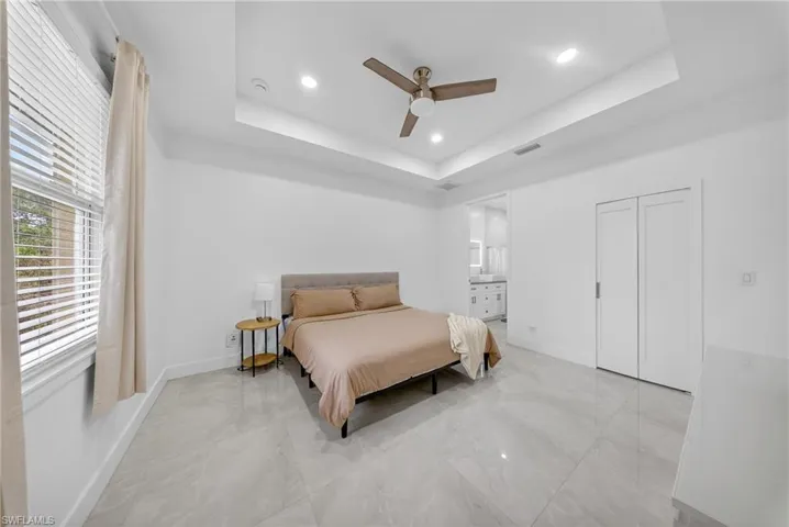 Bedroom featuring a ceiling fan, light marble finish floors, recessed lighting, and ensuite bathroom