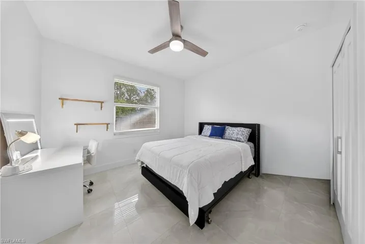 Bedroom featuring ceiling fan, a desk, and a closet