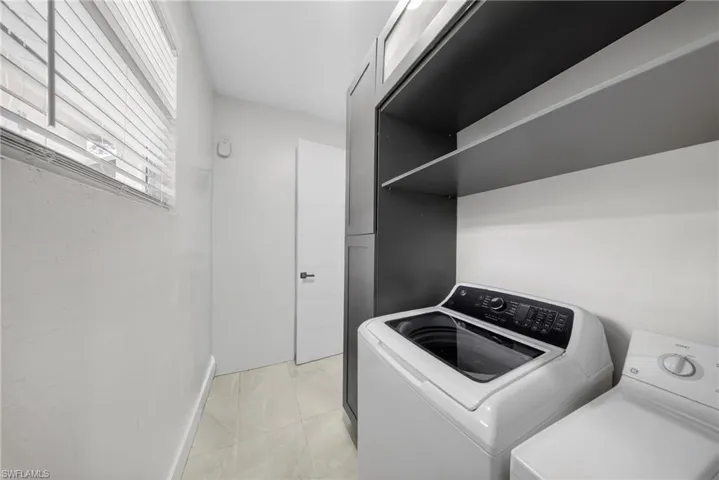 Laundry area featuring washer and dryer and baseboards