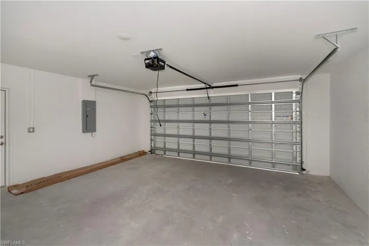 Garage featuring electric panel and a garage door opener