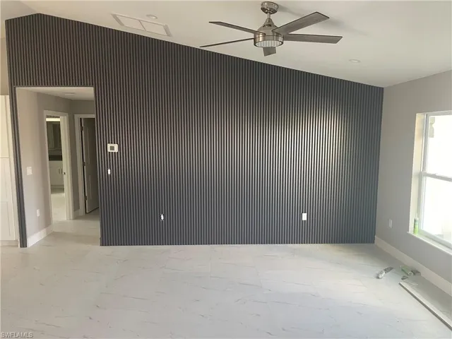 Unfurnished room featuring baseboards and ceiling fan