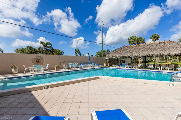 Community pool with a patio area and fence
