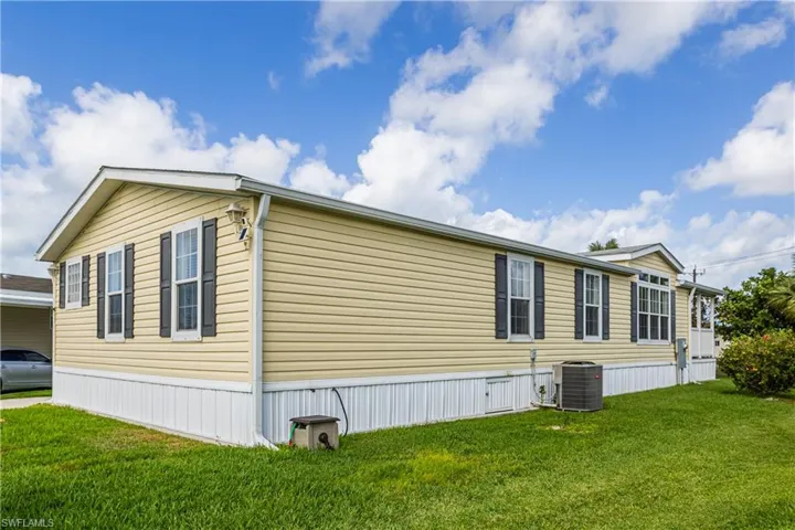 View of home's exterior featuring central AC unit and a yard