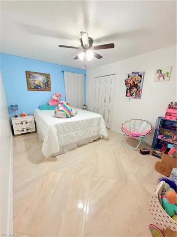 Bedroom featuring a closet, a ceiling fan, and a textured ceiling
