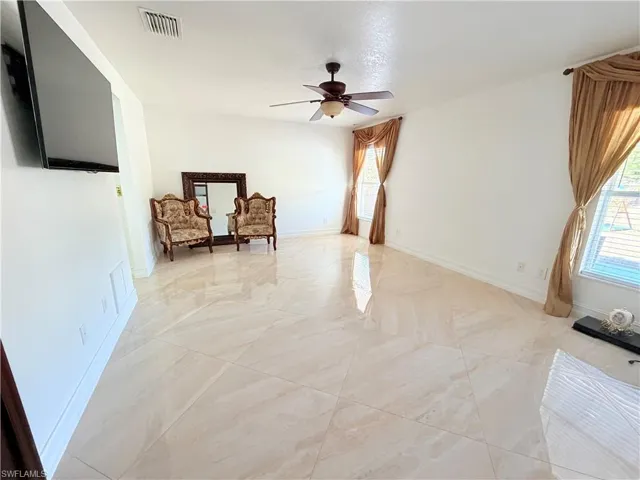 Unfurnished room featuring baseboards and ceiling fan