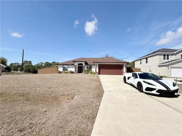 Ranch-style home featuring concrete driveway and an attached garage