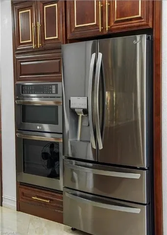Kitchen with stainless steel appliances and dark wood finish cabinetry