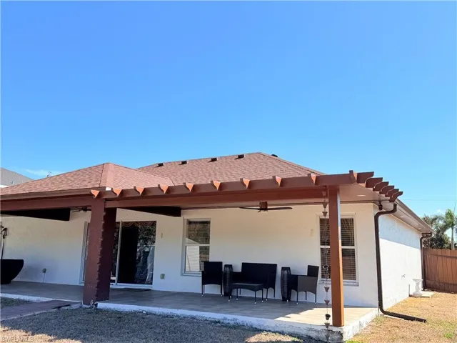 Rear view of house featuring a patio, stucco siding, and a ceiling fan