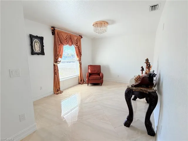 Sitting room featuring baseboards and suspended lighting