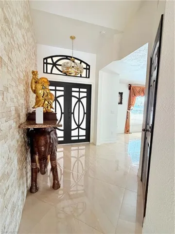 Entrance foyer with french doors and hanging lights
