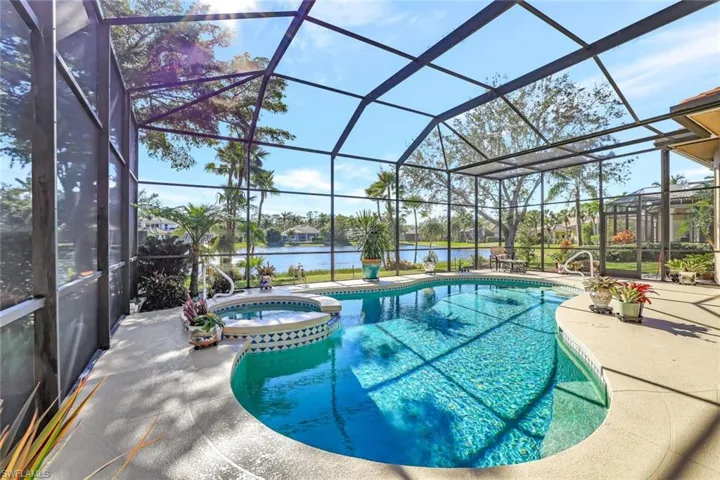 Heated swimming pool, an in ground hot tub, a patio area, picturesque water view, all under a screened-in lanai