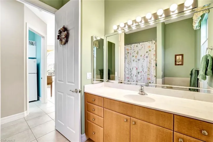 This guest bathroom with it's tile floors has a vanity and a shower/tub combination.