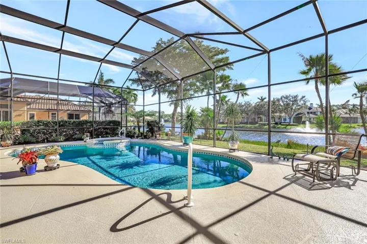 Amazing lake view, heated swimming pool featuring an in ground hot tub, a patio area, and a screened-in lanai