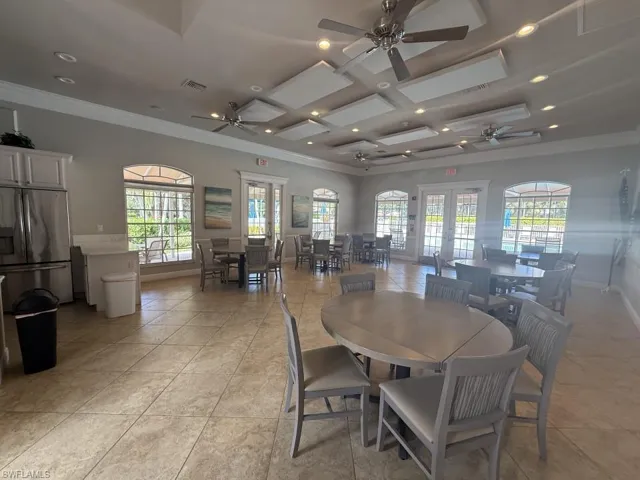 Dining room with recessed lighting, plenty of natural light, coffered ceiling, a ceiling fan, and crown molding