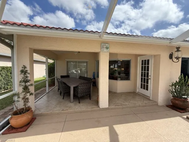 View of patio with a sunroom and outdoor dining space