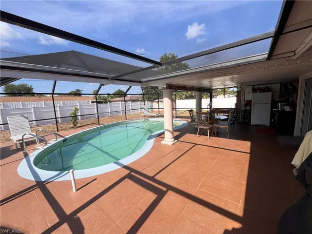 View of pool with a lanai and a patio area