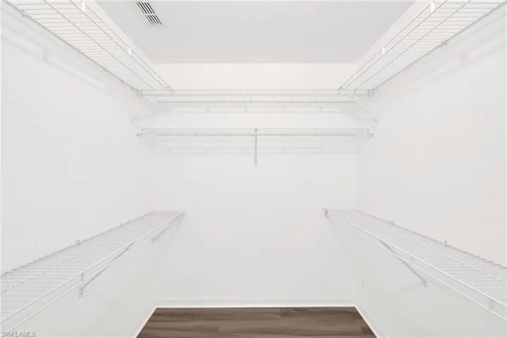 Spacious closet featuring dark wood-style floors