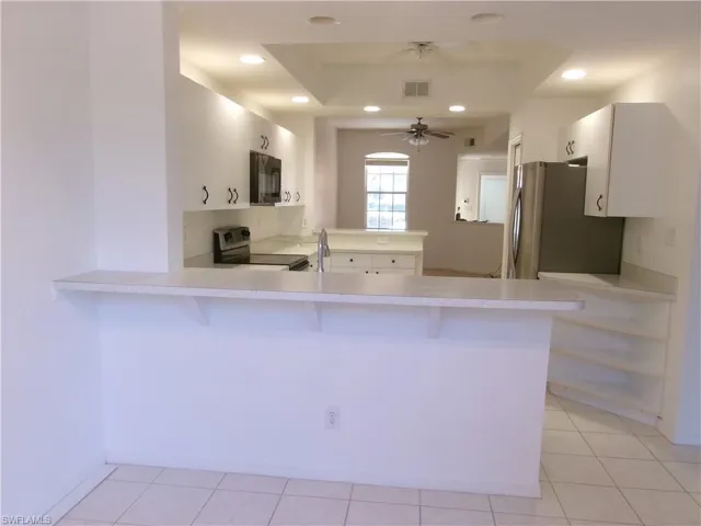 Kitchen featuring a peninsula, stainless steel appliances, light countertops, and visible vents