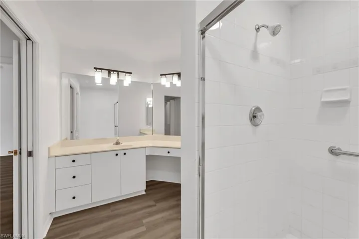 Full bathroom with a shower stall, vanity, and wood finished floors