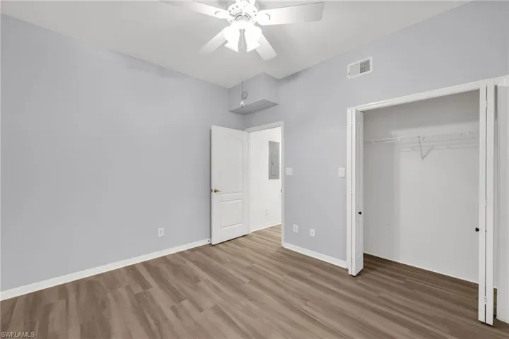 Unfurnished bedroom featuring wood finished floors, a closet, and a ceiling fan