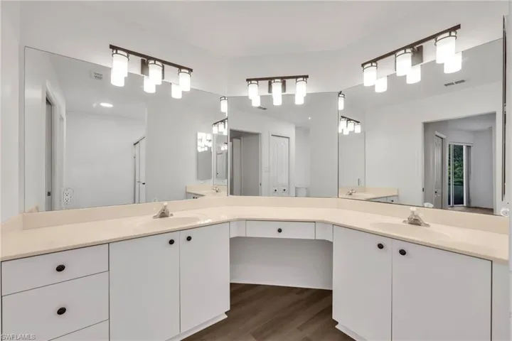 Bathroom with double vanity and wood finished floors