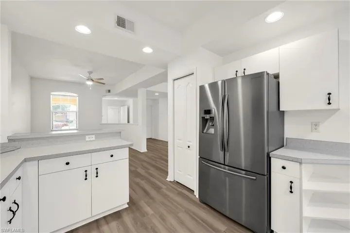 Kitchen with stainless steel fridge with ice dispenser, light countertops, ceiling fan, white cabinets, and recessed lighting