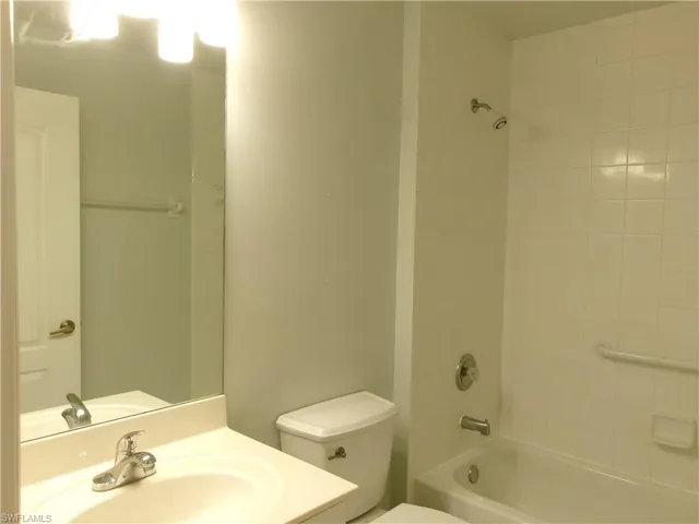 Bathroom with toilet, shower / tub combination, and vanity