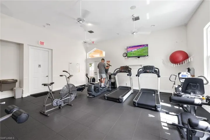 Gym featuring ceiling fan and baseboards