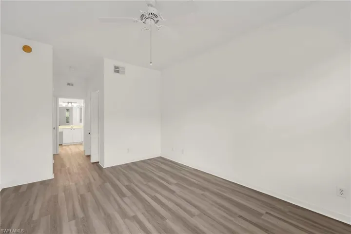 Empty room with wood finished floors and a ceiling fan