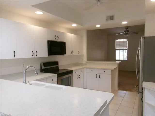Kitchen featuring stainless steel appliances, a peninsula, a ceiling fan, recessed lighting, and a sink