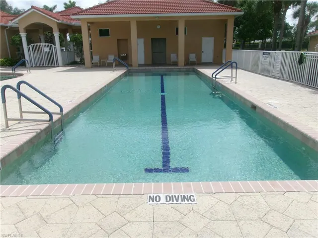 Community pool featuring a patio and fence