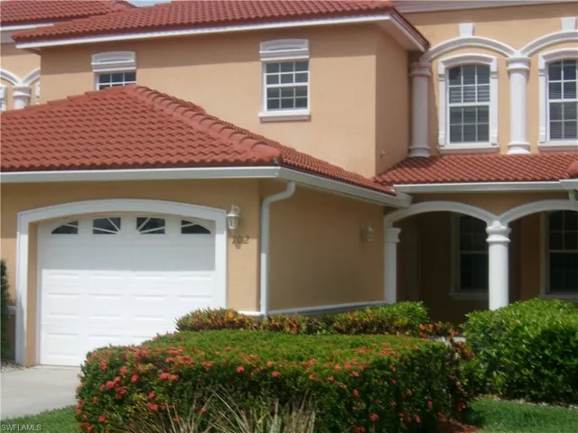 Mediterranean / spanish house featuring stucco siding, a tile roof, and a garage